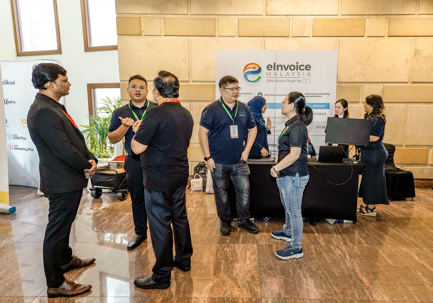 The Ooroboros team talking with visitors at the eInvoice Malaysia booth, Zoholics APAC