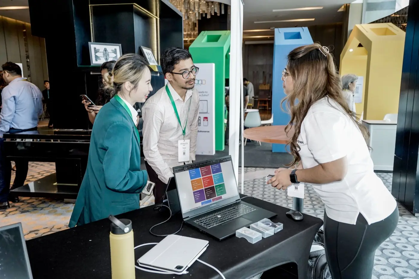 Attendees working through a laptop demonstration at the Ooroboros booth, Zoholics APAC